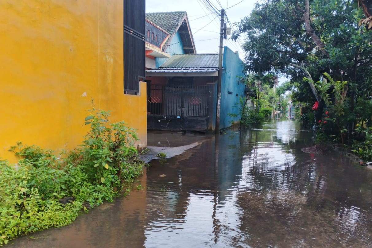 LOMBOK BARAT – Hujan lebat dengan intensitas tinggi yang melanda wilayah Kecamatan Labuapi, Kabupaten Lombok Barat, Nusa Tenggara Barat (NTB), telah memicu genangan air di sejumlah titik, khususnya di Desa Perampuan. Pihak kepolisian segera bergerak melakukan pemantauan untuk memastikan keamanan dan keselamatan warga terdampak. Kapolsek Labuapi, Polres Lombok Barat, Polda NTB, Ipda I Nyoman Rudi Santosa, memimpin langsung kegiatan monitoring dan pengecekan dampak cuaca ekstrem tersebut pada hari Selasa, 2 Desember 2025, sejak pukul 06.00 WITA. Fokus utama pengecekan adalah di beberapa dusun di Desa Perampuan yang dilaporkan terendam banjir. Genangan Air Capai Lutut di Empat Dusun Desa Perampuan Hasil pemantauan di lapangan menunjukkan bahwa genangan air cukup signifikan terjadi di beberapa dusun di Desa Perampuan. Ketinggian air diperkirakan bervariasi, mulai dari sebatas mata kaki hingga mencapai setinggi lutut orang dewasa. Kondisi ini memaksa sejumlah warga di salah satu dusun untuk mengungsi sebagai langkah antisipasi. Menurut Ipda I Nyoman Rudi Santosa, genangan air tersebut disebabkan oleh kombinasi beberapa faktor. "Tingginya intensitas hujan yang turun dalam waktu lama menjadi pemicu utama. Selain itu, wilayah Desa Perampuan ini merupakan dataran rendah. Kondisi ini diperparah dengan tidak tersedianya sistem drainase yang memadai untuk mengalirkan debit air yang berlebihan," jelasnya. Empat dusun yang terpantau mengalami genangan air adalah: Dusun Kerepet: Terpantau genangan air, dan sekitar 10 Kepala Keluarga (KK) dari Perumahan Pepabri memilih untuk mengungsi sementara di Mushola Baitussuhada. Dusun Karang Bayan: Masih terdapat genangan air namun dilaporkan sudah mulai berangsur surut. Warga di dusun ini tidak ada yang mengungsi. Dusun Kapitan: Genangan air juga terjadi dan mulai surut secara perlahan. Tidak ada laporan warga yang mengungsi dari dusun ini. Dusun Bayan Pengsong: Genangan air mulai surut, dan warga memilih untuk tetap bertahan di rumah masing-masing. Masyarakat Diimbau Tetap Waspada dan Kooperatif Meskipun genangan air masih terjadi di beberapa titik, situasi secara umum mulai terkendali seiring dengan meredanya curah hujan. Sebagian besar warga yang terdampak, kecuali belasan KK yang masih berada di pengungsian, telah kembali menjalankan aktivitasnya seperti biasa. Berdasarkan laporan terkini, tidak terdapat kerugian material yang signifikan yang dialami oleh warga terdampak. Ipda I Nyoman Rudi Santosa menekankan pentingnya kewaspadaan masyarakat, mengingat potensi cuaca ekstrem yang masih mungkin terjadi di tengah musim penghujan ini. "Kami terus memonitor perkembangan situasi di seluruh wilayah Labuapi. Kami mengimbau kepada seluruh masyarakat, terutama yang tinggal di daerah rawan banjir, untuk selalu waspada dan memantau informasi cuaca dari pihak berwenang. Segera laporkan kepada perangkat desa atau Bhabinkamtibmas setempat jika terjadi peningkatan debit air yang mengkhawatirkan," ujar Ipda I Nyoman Rudi Santosa. Langkah Penanganan dan Antisipasi Lebih Lanjut Pihak kepolisian sektor Labuapi, bersama dengan tim gabungan dari unsur TNI, Pemerintah Desa, dan Badan Penanggulangan Bencana Daerah (BPBD) Lombok Barat, telah berkoordinasi erat untuk penanganan dan antisipasi bencana. Koordinasi ini mencakup penyediaan lokasi pengungsian sementara, pemeriksaan kondisi kesehatan warga terdampak, serta langkah-langkah mitigasi jangka panjang terkait sistem drainase. Fenomena banjir yang berulang di wilayah dataran rendah Labuapi, khususnya Desa Perampuan, menunjukkan perlunya solusi permanen terkait tata kelola air dan tata ruang. Pembangunan infrastruktur penanggulangan banjir yang berkelanjutan, seperti normalisasi sungai dan pembangunan drainase yang terintegrasi, sangat krusial untuk mencegah terulangnya kejadian serupa di masa mendatang. "Kehadiran kami di lokasi adalah bentuk komitmen Polri untuk selalu hadir di tengah masyarakat. Kami akan terus bekerja sama dengan semua pihak terkait agar dampak bencana cuaca ekstrem dapat diminimalisir. Yang terpenting, keselamatan warga adalah prioritas utama kami," tutup Ipda I Nyoman Rudi Santosa. Pemerintah Daerah juga diharapkan dapat mengambil langkah cepat dalam penataan infrastruktur lingkungan, terutama di wilayah yang padat penduduk dan sering tergenang, guna memastikan Labuapi dapat lebih tangguh menghadapi ancaman bencana hidrometeorologi.